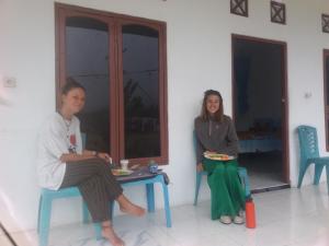 Un uomo e una donna seduti a un tavolo di Rice field guest house a Kelimutu
