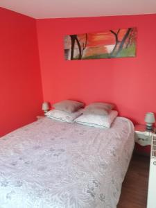 een slaapkamer met rode muren en een bed met 2 kussens bij maison calme avec piscine palmiers 300m de la plage pornichet centre in Pornichet