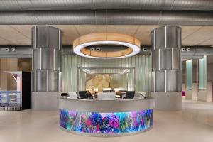 a lobby with a reception desk and a chandelier at Aloft Kuala Lumpur Sentral in Kuala Lumpur