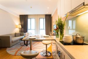 a kitchen and living room with a table and a couch at Modena By Fraser New District Wuxi in Wuxi