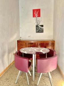 une table et des chaises dans une pièce avec un tableau dans l'établissement Summerset Residence Negril, à Negril