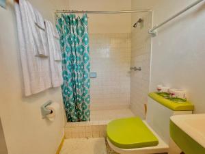 a bathroom with a green toilet and a shower at Summerset Residence Negril in Negril