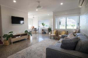 a living room with a couch and a tv at Iona Mission Beach- Stroll to shops cafes & beach in Mission Beach