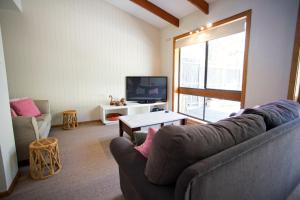 ein Wohnzimmer mit einem Sofa und einem TV in der Unterkunft Lytton at Lonnie in Point Lonsdale