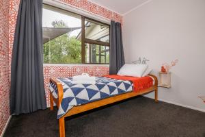 a bedroom with a bed and a window at As You Do in Rotorua
