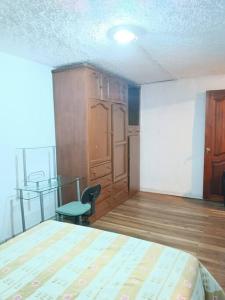 キトにあるLindo Departamento amoblado en el Centro de Quitoのベッドルーム1室(ベッド1台、テーブル、椅子付)