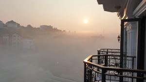 Un matin brumeux avec le soleil se lever au-dessus de l'eau dans l'établissement Sunset Hill Dalat, à Đà Lạt