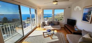 uma sala de estar com vista para o oceano em Watch The Sunrise Over Coogee 2 Bedrooms+Garage em Sidney