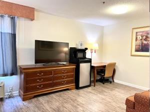 Habitación de hotel con TV y escritorio. en FairBridge Inn Express Mount Vernon, en Mount Vernon