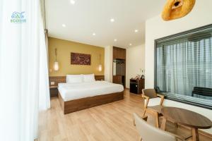 a hotel room with a bed and a table and chairs at CAO BANG ECO HOUSE in Cao Bằng