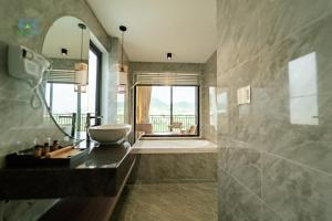 a bathroom with a sink and a tub and a mirror at CAO BANG ECO HOUSE in Cao Bằng