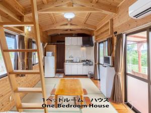 a tiny house with a staircase and a kitchen at もとぶいこいの宿 やまちゃん in Motobu