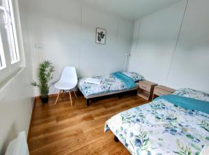 a bedroom with two beds and a desk and a chair at Marzenie Dziadka - siedlisko obok Augustowa 