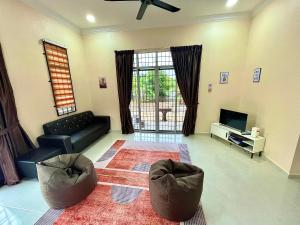a living room with a couch and a tv at King's Cottage Homestay Kubang Kerian in Kota Bharu