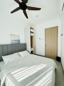 - une chambre avec un grand lit blanc et un ventilateur de plafond dans l'établissement NELI HOMESTAY @LADANG TANJUNG TERENGGANU, à Kuala Terengganu