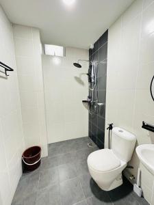 La salle de bains blanche est pourvue de toilettes et d'un lavabo. dans l'établissement NELI HOMESTAY @LADANG TANJUNG TERENGGANU, à Kuala Terengganu