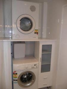 una lavatrice e asciugatrice in una piccola stanza di CLIVE-Heart of Sydney, Modern, Rooftop Pool Access a Sydney