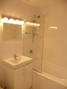 a white bathroom with a sink and a shower at CLIVE-Heart of Sydney, Modern, Rooftop Pool Access in Sydney