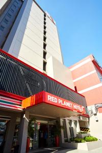 um edifício de hotel de planeta vermelho com um sinal de hotel de planeta vermelho em Red Planet Quezon City Timog em Manilla