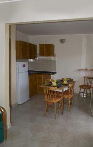 a kitchen with a table and chairs and a white refrigerator at Villa Dacla in Lampedusa