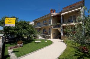 ein Gebäude mit einem Schild, das den Garten des Apartments liest in der Unterkunft Apartments Maria in Poreč