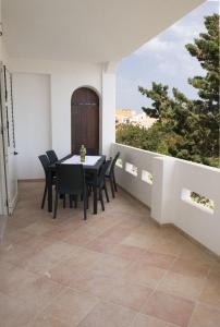 a dining room with a table and chairs on a balcony at Villa Dacla in Lampedusa