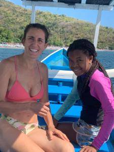 dos mujeres sentadas en un barco en el agua en Tradisi Villas, en Amed