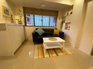 a living room with a couch and a table at Scarlett 102, Chapel Road by Connekt Homes in Mumbai