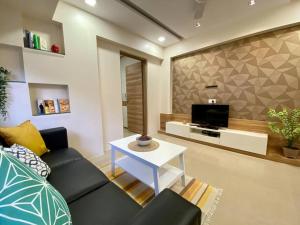 a living room with a couch and a tv at Scarlett 102, Chapel Road by Connekt Homes in Mumbai