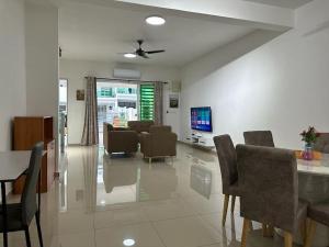 a dining room and living room with a table and chairs at 2 Storey, Hijayu 3D Alconix, Sendayan, Seremban in Seremban