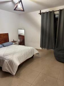 una camera con letto, sedia e specchio di Namasté departamentos a Città di Oaxaca