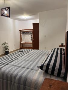 una camera da letto con un grande letto con una coperta a righe di Namasté departamentos a Città di Oaxaca