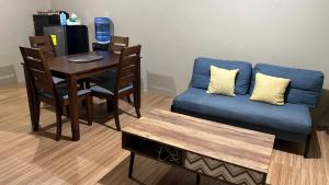 Aldea Vacation Home في Sibulan: غرفة معيشة مع أريكة زرقاء وطاولة