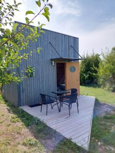 a house with a table and chairs on a deck at Päikesemajake 2 in Soonlepa