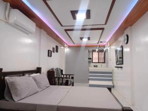 a bedroom with a bed and a ceiling with lights at Fabuluz Luxury at Princess Place in Malolos