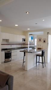a large kitchen with white cabinets and a table at Duplex solar in Federación