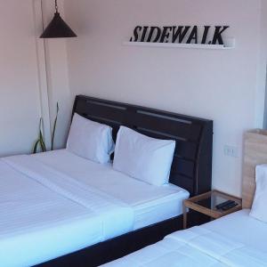 - 2 lits avec des oreillers blancs dans une chambre dans l'établissement Sidewalk Boutique Hotel, à Ko Samet