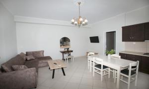 a living room with a couch and a table and a kitchen at BABI'S VILLA - Garden apartment in Lixouri