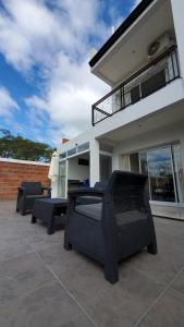 a patio with chairs and tables in front of a house at Duplex solar in Federación