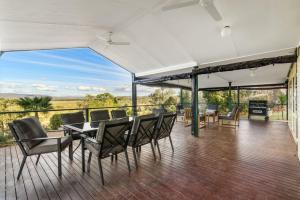 a dining room with a table and chairs on a deck at Reflections Lake Burrendong - Holiday Park in Mumbil