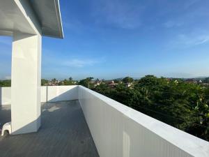 einen Balkon eines Hauses mit einer weißen Wand in der Unterkunft Max n Fe in Iriga City