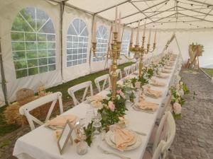 a long table in a marquee with white tables and flowers at Domaine de Lardoisière in Château-Salins