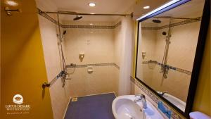 een badkamer met een douche, een wastafel en een toilet bij Lotus Desaru Beach Resort & Spa in Desaru