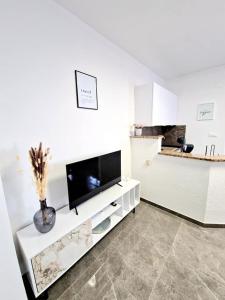 a white living room with a flat screen tv at Apartments Tadic in Omišalj