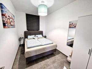 a bedroom with a bed in a white room at Apartments Tadic in Omišalj