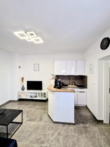 cocina con armarios blancos y encimera en Apartments Tadic en Omišalj