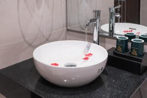 baño con lavabo blanco en la encimera en Navy Hotel Hà Nội, en Hanói