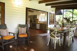 - une cuisine et une salle à manger avec une table et des chaises dans l'établissement Lillypads Yellow Cottage - Rainforest Getaway, à Mission Beach