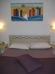 a bedroom with a bed with a painting on the wall at Guesthouse Irene in Afissos