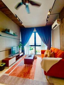 ein Wohnzimmer mit einem roten Sofa und blauen Vorhängen in der Unterkunft AuranadTroikaKB Apartment Wifi-Netflix-Coway in Kota Bharu